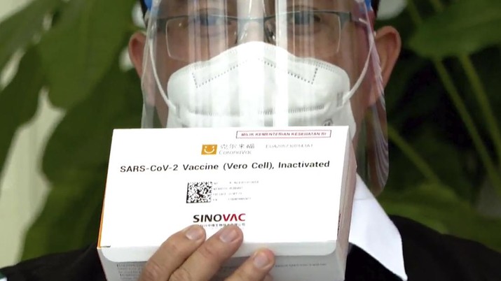 In this image made from a video released by Indonesian Presidential Palace, a Health Ministry official shows a box of COVID-19 vaccine that will be given to President Joko Widodo at Merdeka Palace in Jakarta, Indonesia, Wednesday, Jan. 13, 2021. Widodo on Wednesday received the first shot of a Chinese-made COVID-19 vaccine after Indonesia approved it for emergency use and began efforts to vaccine millions of people in the world's fourth most populated country. (Indonesian Presidential Palace via AP)