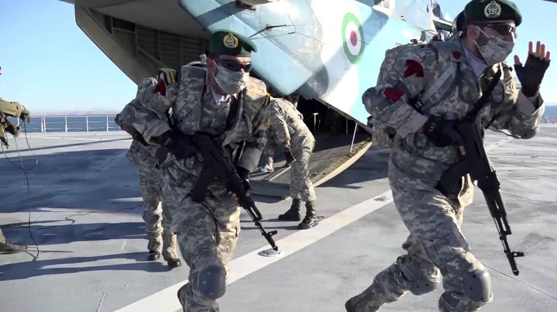 This image made from a video released on Wednesday, Jan. 13, 2021, by the Iranian Army shows troops leaving a helicopter on Makran logistics vessel during a navy drill. Iran's navy began a short-range missile drill in the Gulf of Oman on Wednesday, state TV reported, amid heightened regional tensions over Tehran's nuclear program and a U.S. pressure campaign against the Islamic Republic. (Iranian Army via AP)