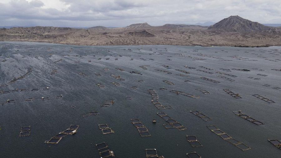 Fish pens areas are seen at the lake surrounding Taal volcano almost a year after it erupted on Sunday, Jan. 10, 2021 in Agoncillo town, Batangas province, Philippines. A popular tourist destination just south of Manila because of its picturesque setting in the middle of a lake, Taal erupted on Jan. 12, 2020. The eruption displaced thousands of villagers living near the area and delivered an early crisis this year for one of the world's most disaster-prone nations a couple of months before the COVID-19 pandemic broke in the country. (AP Photo/Aaron Favila)