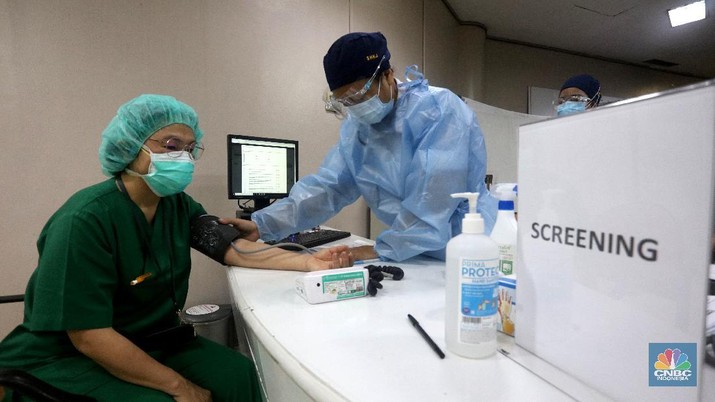 Petugas medis menyuntikan vaksin Covid-19 Sinovac kepada tenaga medis di Rumah Sakit Siloam, Jakarta (14/1/2021). Vaksinasi tahap awal akan menargetkan 1,48 juta Nakes yang di jadwalkan berlangsung Januari 2021. (CNBC Indonesia/Tri Susilo)