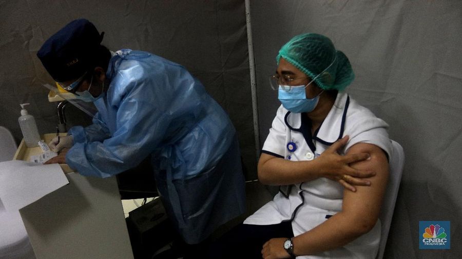 Petugas medis menyuntikan vaksin Covid-19 Sinovac kepada tenaga medis di Rumah Sakit Siloam, Jakarta (14/1/2021). Vaksinasi tahap awal akan menargetkan 1,48 juta Nakes yang di jadwalkan berlangsung Januari 2021. (CNBC Indonesia/Tri Susilo)