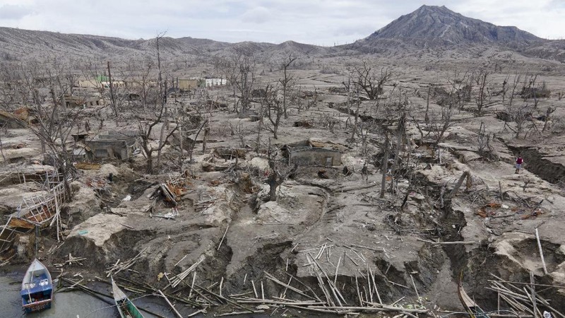 Damaged houses lie at Taal volcano almost a year after it erupted on Sunday, Jan. 10, 2021 in Batangas province, Philippines. A popular tourist destination just south of Manila because of its picturesque setting in the middle of a lake, Taal erupted on Jan. 12, 2020. The eruption displaced thousands of villagers living near the area and delivered an early crisis this year for one of the world's most disaster-prone nations a couple of months before the COVID-19 pandemic broke in the country. (AP Photo/Aaron Favila)
