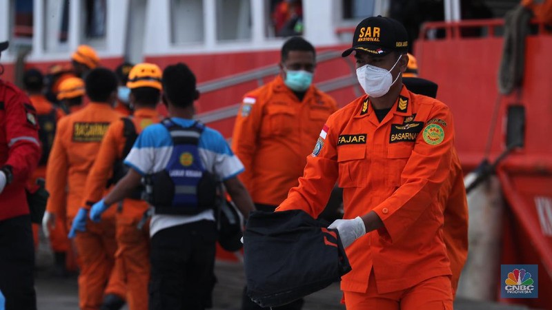 Petugas Basarnas menurunkan kantong jenazah dan puing korban pesawat Sriwijaya Air SJ182 yang jatuh di perairan Kepulauan Seribu, Kamis (14/1/2021). Selanjutnya tim Basarnas menyerahkan beberapa kantong jenazah yang telah dikumpulkan kepada Tim DVI dan KNKT untuk pemeriksaan (CNBC Indonesia/ Tri Susilo)