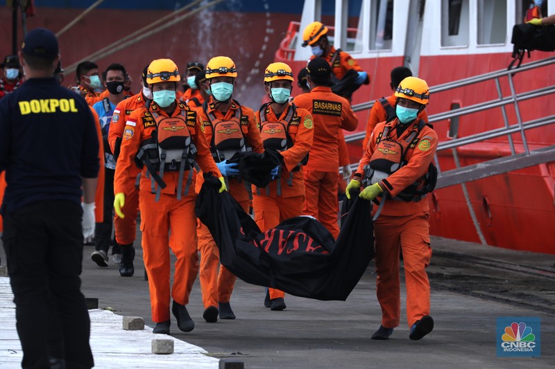 Petugas Basarnas menurunkan kantong jenazah dan puing korban pesawat Sriwijaya Air SJ182 yang jatuh di perairan Kepulauan Seribu, Kamis (14/1/2021). Selanjutnya tim Basarnas menyerahkan beberapa kantong jenazah yang telah dikumpulkan kepada Tim DVI dan KNKT untuk pemeriksaan (CNBC Indonesia/ Tri Susilo)