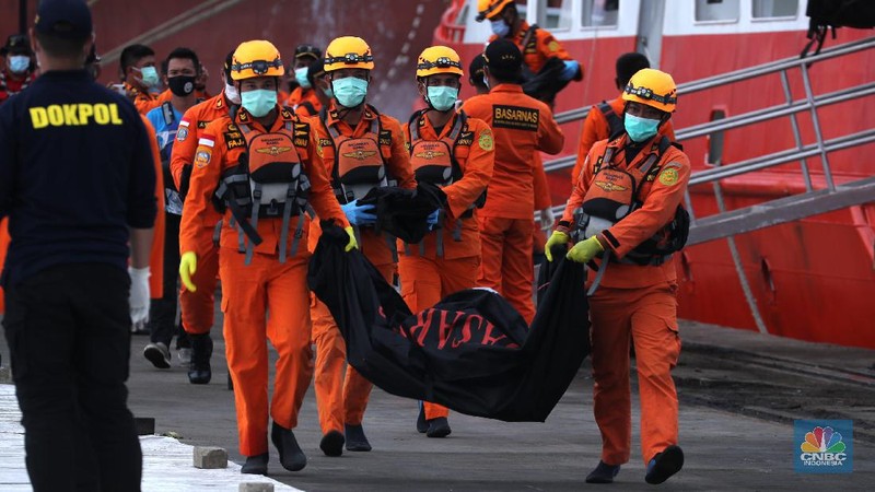 Petugas Basarnas menurunkan kantong jenazah dan puing korban pesawat Sriwijaya Air SJ182 yang jatuh di perairan Kepulauan Seribu, Kamis (14/1/2021). Selanjutnya tim Basarnas menyerahkan beberapa kantong jenazah yang telah dikumpulkan kepada Tim DVI dan KNKT untuk pemeriksaan (CNBC Indonesia/ Tri Susilo)