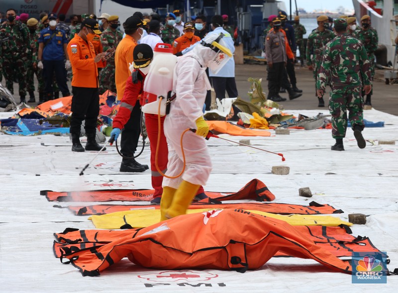Petugas Basarnas menurunkan kantong jenazah dan puing korban pesawat Sriwijaya Air SJ182 yang jatuh di perairan Kepulauan Seribu, Kamis (14/1/2021). (CNBC Indonesia/ Tri Susilo) Petugas Basarnas menurunkan kantong jenazah dan puing korban pesawat Sriwijaya Air SJ182 yang jatuh di perairan Kepulauan Seribu, Kamis (14/1/2021). Selanjutnya tim Basarnas menyerahkan beberapa kantong jenazah yang telah dikumpulkan kepada Tim DVI dan KNKT untuk pemeriksaan (CNBC Indonesia/ Tri Susilo)