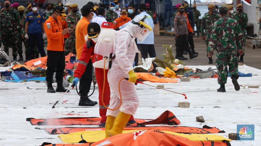 Petugas Basarnas menurunkan kantong jenazah dan puing korban pesawat Sriwijaya Air SJ182 yang jatuh di perairan Kepulauan Seribu, Kamis (14/1/2021). Selanjutnya tim Basarnas menyerahkan beberapa kantong jenazah yang telah dikumpulkan kepada Tim DVI dan KNKT untuk pemeriksaan (CNBC Indonesia/ Tri Susilo)