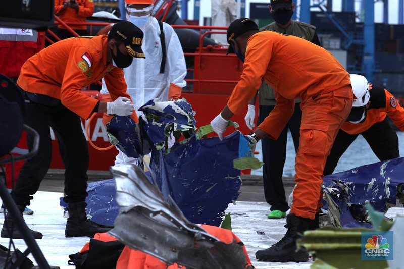 Petugas Basarnas menurunkan kantong jenazah dan puing korban pesawat Sriwijaya Air SJ182 yang jatuh di perairan Kepulauan Seribu, Kamis (14/1/2021). (CNBC Indonesia/ Tri Susilo) Petugas Basarnas menurunkan kantong jenazah dan puing korban pesawat Sriwijaya Air SJ182 yang jatuh di perairan Kepulauan Seribu, Kamis (14/1/2021). Selanjutnya tim Basarnas menyerahkan beberapa kantong jenazah yang telah dikumpulkan kepada Tim DVI dan KNKT untuk pemeriksaan (CNBC Indonesia/ Tri Susilo)