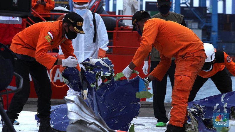 Petugas Basarnas menurunkan kantong jenazah dan puing korban pesawat Sriwijaya Air SJ182 yang jatuh di perairan Kepulauan Seribu, Kamis (14/1/2021). Selanjutnya tim Basarnas menyerahkan beberapa kantong jenazah yang telah dikumpulkan kepada Tim DVI dan KNKT untuk pemeriksaan (CNBC Indonesia/ Tri Susilo)