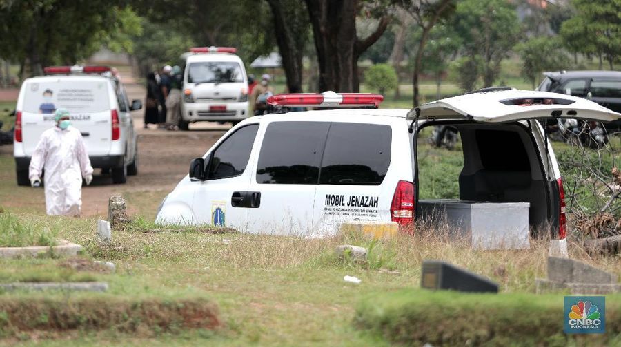 Petugas membawa peti jenazah yang akan dimakamkan dengan protokol COVID-19 di area khusus TPU Srengseng Sawah, Jakarta, Jumat (15/1/2021). TPU Srengseng Sawah mulai menerima pemakaman jenazah dengan protokol COVID-19 sejak Selasa (12/1) lalu. Menurut petugas makam dalam tiga hari terakhir sudah 164 jenazah Covid-19 yang dikubur di TPU tersebut. Lahan pemakaman di Pondok Rangon dan Tegal Alur yang saat ini menjadi lahan pemakaman pasien Corona Virus Desease 2019 (COVID-19) yang hampir penuh. Meski untuk jenazah pasien Covid 19, jenazah non Covid-19 masih bisa digunakan untuk pemakaman. Pantauan CNBC Indonesia sampai pukul 14.00 wib sudah 20 jenazah yang dimakamkan, dan kemungkinan akan bertambah lagi. Ada empat TPU di wilayah Jakarta yang digunakan untuk memakamkan jenazah pasien Covid-19, yakni TPU Tegal Alur di Jakarta Barat, TPU Pondok Ranggon di Jakarta Timur, TPU Rorotan di Jakarta Utara, dan TPU Srengseng Sawah. Dikutip dari CNN Indonesia pada Kamis, 14/1, Kepala Suku Dinas Pertamanan dan Hutan Kota Jakarta Selatan Winarto mengatakan, lahan di TPU Srengseng Sawah digunakan untuk memakamkan jenazah Covid-19 muslim. Dalam menangani krisis lahan pemakaman ini, pihak TPU Pondok Ranggon maupun TPU Tegal Alur juga menerapkan makam tumpang. Namun, mekanisme tersebut harus mendapat izin pihak keluarga. (CNBC Indonesia/ Muhammad Sabki)