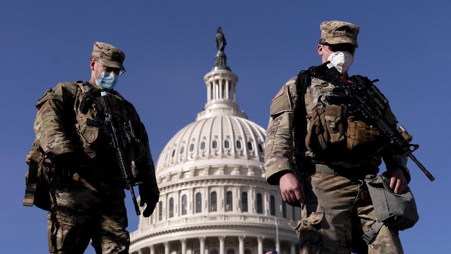 Military trucks are stationed behind perimeter fencing near Union Station on Capitol Hill in Washington, Thursday, Jan. 14, 2021. (AP Photo/Andrew Harnik)