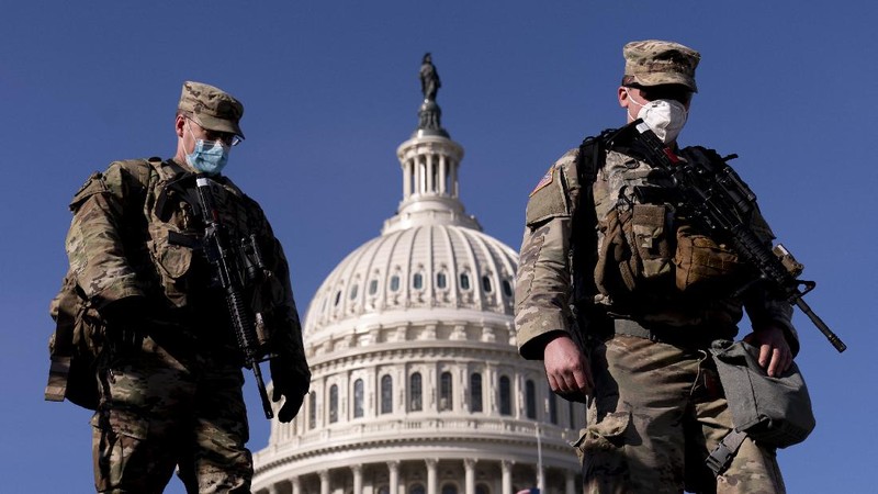 Military trucks are stationed behind perimeter fencing near Union Station on Capitol Hill in Washington, Thursday, Jan. 14, 2021. (AP Photo/Andrew Harnik)