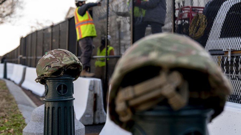 Military trucks are stationed behind perimeter fencing near Union Station on Capitol Hill in Washington, Thursday, Jan. 14, 2021. (AP Photo/Andrew Harnik)
