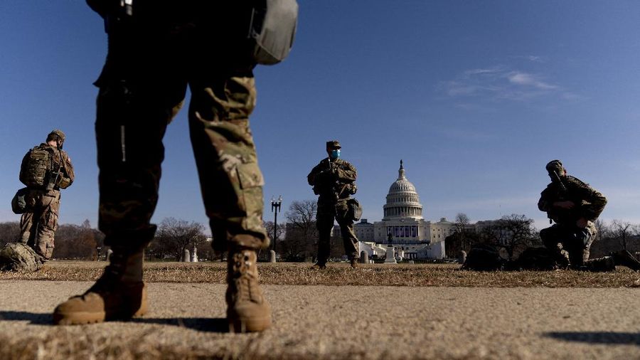 Military trucks are stationed behind perimeter fencing near Union Station on Capitol Hill in Washington, Thursday, Jan. 14, 2021. (AP Photo/Andrew Harnik)