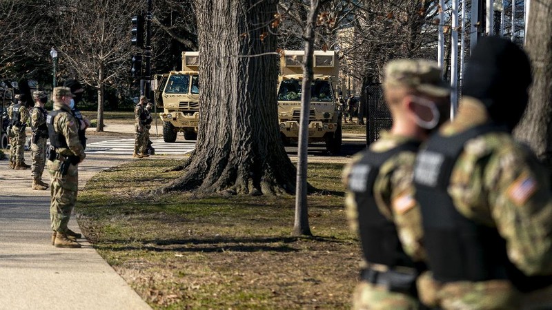 Military trucks are stationed behind perimeter fencing near Union Station on Capitol Hill in Washington, Thursday, Jan. 14, 2021. (AP Photo/Andrew Harnik)