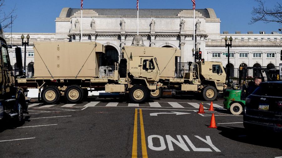Military trucks are stationed behind perimeter fencing near Union Station on Capitol Hill in Washington, Thursday, Jan. 14, 2021. (AP Photo/Andrew Harnik)