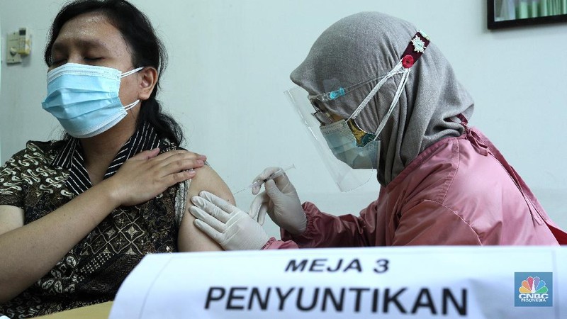 Petugas kesehatan menyuntikan vaksin Covid-19 Sinovac ke tenaga kesehatan di Puskesmas Kecamatan Kebayoran Lama, Jumat (15/1/2021). Vaksinasi kepada para tenaga kesehatan tersebut sebagai upaya penanggulangan pandami Covid-19. (CNBC Indonesia/Tri Susilo)