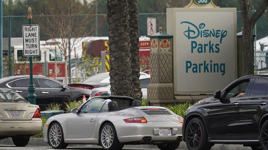 People walk after receiving their vaccines at the Disneyland Resort, serving as a Super POD (Point of Dispensing) COVID-19 mass vaccination site in Anaheim, Calif., Wednesday, Jan. 13, 2021. The parking lot is located off Katella Avenue and sits southeast of Disneyland. California is immediately allowing residents 65 and older to get scarce coronavirus vaccines, Gov. Gavin Newsom announced Wednesday. (AP Photo/Damian Dovarganes)