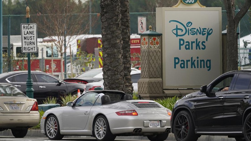 People walk after receiving their vaccines at the Disneyland Resort, serving as a Super POD (Point of Dispensing) COVID-19 mass vaccination site in Anaheim, Calif., Wednesday, Jan. 13, 2021. The parking lot is located off Katella Avenue and sits southeast of Disneyland. California is immediately allowing residents 65 and older to get scarce coronavirus vaccines, Gov. Gavin Newsom announced Wednesday. (AP Photo/Damian Dovarganes)