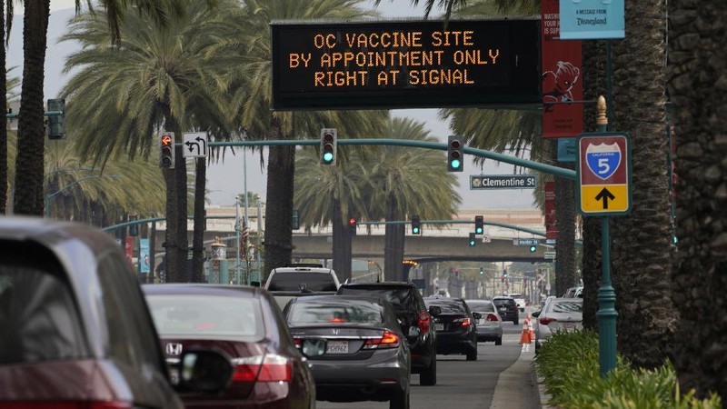 People walk after receiving their vaccines at the Disneyland Resort, serving as a Super POD (Point of Dispensing) COVID-19 mass vaccination site in Anaheim, Calif., Wednesday, Jan. 13, 2021. The parking lot is located off Katella Avenue and sits southeast of Disneyland. California is immediately allowing residents 65 and older to get scarce coronavirus vaccines, Gov. Gavin Newsom announced Wednesday. (AP Photo/Damian Dovarganes)