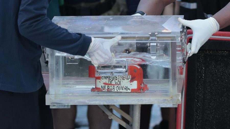 Members of National Transportation Safety Committee carry a box containing the flight data recorder of Sriwijaya Air flight SJ-182 retrieved from the Java Sea where the passenger jet crashed during a press conference at Tanjung Priok Port, Tuesday, Jan. 12, 2021. Indonesian navy divers searching the ocean floor on Tuesday recovered the flight data recorder from a Sriwijaya Air jet that crashed into the Java Sea with 62 people on board. (AP Photo/Dita Alangkara)