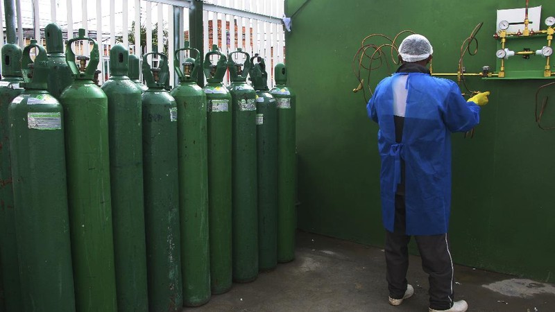 Family members of patients hospitalized with COVID-19 line up with empty oxygen tanks in an attempt to refill them, outside the Nitron da Amazonia company, in Manaus, Amazonas state, Brazil, Friday, Jan. 15, 2021. (AP Photo/Edmar Barros)