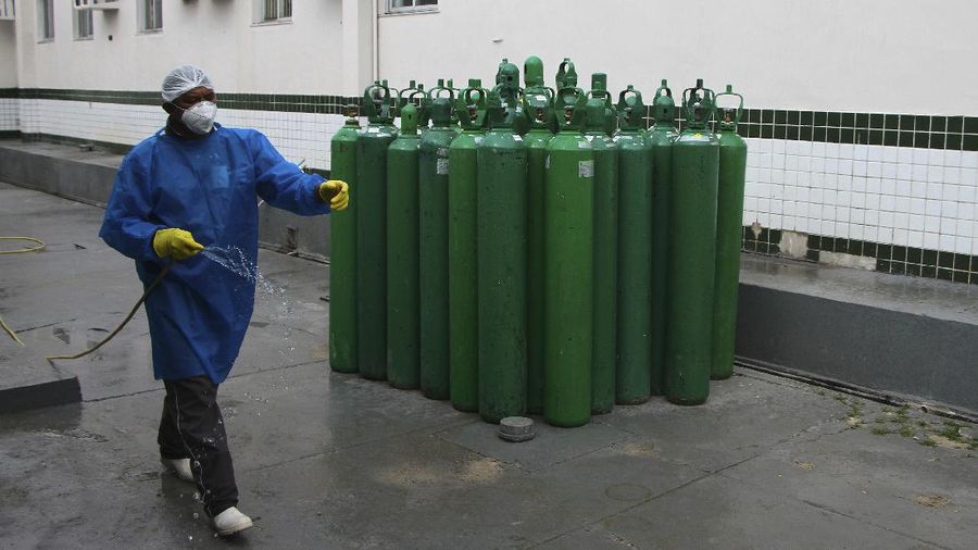 Family members of patients hospitalized with COVID-19 line up with empty oxygen tanks in an attempt to refill them, outside the Nitron da Amazonia company, in Manaus, Amazonas state, Brazil, Friday, Jan. 15, 2021. (AP Photo/Edmar Barros)