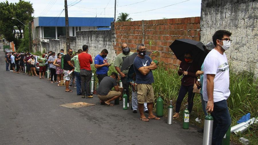 Family members of patients hospitalized with COVID-19 line up with empty oxygen tanks in an attempt to refill them, outside the Nitron da Amazonia company, in Manaus, Amazonas state, Brazil, Friday, Jan. 15, 2021. (AP Photo/Edmar Barros)