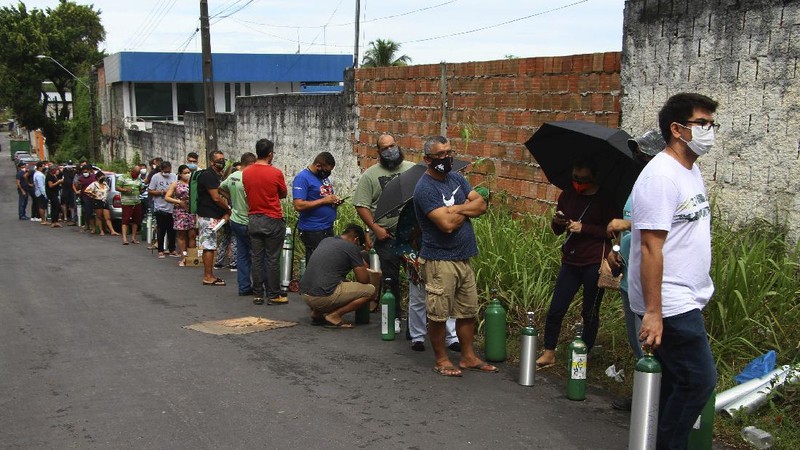 Family members of patients hospitalized with COVID-19 line up with empty oxygen tanks in an attempt to refill them, outside the Nitron da Amazonia company, in Manaus, Amazonas state, Brazil, Friday, Jan. 15, 2021. (AP Photo/Edmar Barros)
