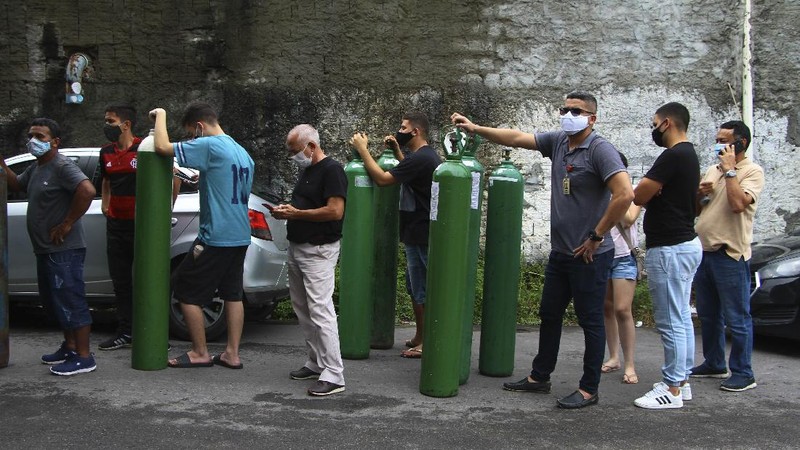 Family members of patients hospitalized with COVID-19 line up with empty oxygen tanks in an attempt to refill them, outside the Nitron da Amazonia company, in Manaus, Amazonas state, Brazil, Friday, Jan. 15, 2021. (AP Photo/Edmar Barros)
