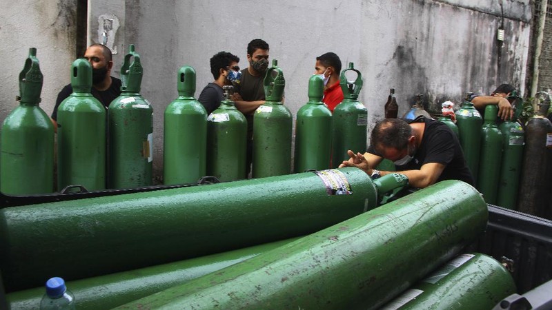 Family members of patients hospitalized with COVID-19 line up with empty oxygen tanks in an attempt to refill them, outside the Nitron da Amazonia company, in Manaus, Amazonas state, Brazil, Friday, Jan. 15, 2021. (AP Photo/Edmar Barros)