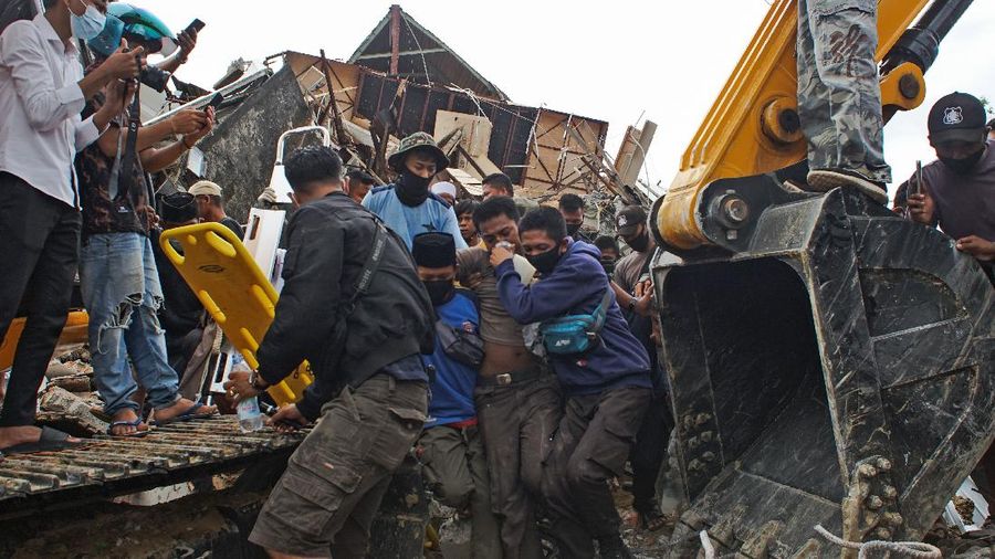 Rescuers search for victims at a village hit by Sunday's landslides in Sumedang, West Java, Indonesia, Monday, Jan. 11, 2021. Landslides triggered by heavy rain in the village left at a number of people died and injured, officials said. (AP Photo/Sorasoca)