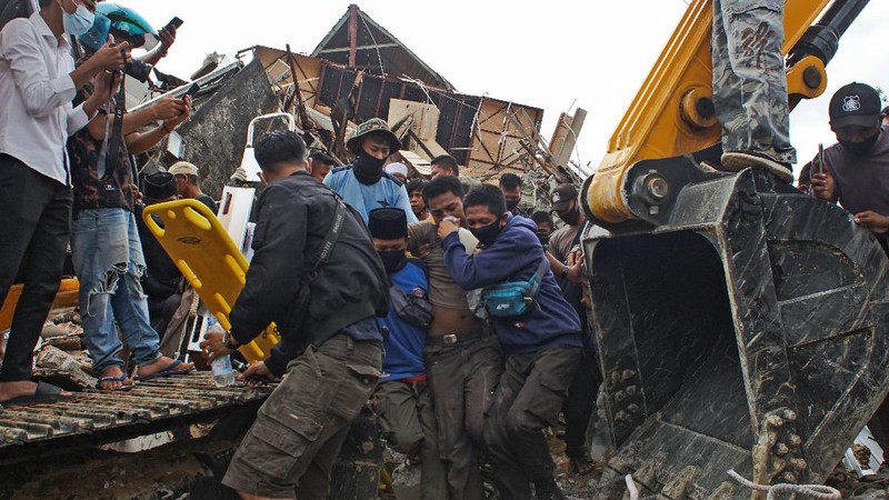 Rescuers search for victims at a village hit by Sunday's landslides in Sumedang, West Java, Indonesia, Monday, Jan. 11, 2021. Landslides triggered by heavy rain in the village left at a number of people died and injured, officials said. (AP Photo/Sorasoca)