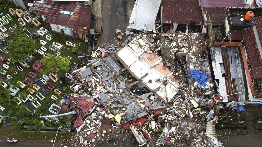 A building is seen badly damaged following an earthquake in this aerial photo taken using a drone in Mamuju, West Sulawesi, Indonesia, Saturday, Jan. 16, 2021. Damaged roads and bridges, power blackouts and lack of heavy equipment on Saturday hampered Indonesia's rescuers after a strong and shallow earthquake left a number of people dead and injured on Sulawesi island. (AP Photo/Abdi Latief)