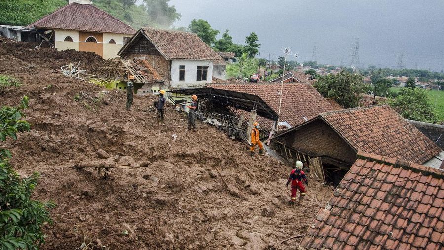 Rescuers search for victims at a village hit by Sunday's landslides in Sumedang, West Java, Indonesia, Monday, Jan. 11, 2021. Landslides triggered by heavy rain in the village left at a number of people died and injured, officials said. (AP Photo/Sorasoca)