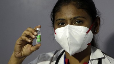 A health worker shows COVID-19 vaccine in Mumbai, India, Saturday, Jan. 16, 2021. India started inoculating health workers Saturday in what is likely the world's largest COVID-19 vaccination campaign, joining the ranks of wealthier nations where the effort is already well underway. (AP Photo/Rajanish Kakade)
