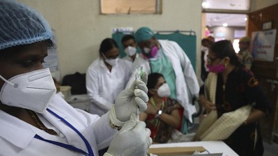 Vaksinasi covid-19 di India A health worker, left, prepares to administer COVID-19 vaccine to a doctor at a government Hospital in Hyderabad, India, Saturday, Jan. 16, 2021. India started inoculating health workers Saturday in what is likely the world's largest COVID-19 vaccination campaign, joining the ranks of wealthier nations where the effort is already well underway. (AP Photo/Mahesh Kumar A.)