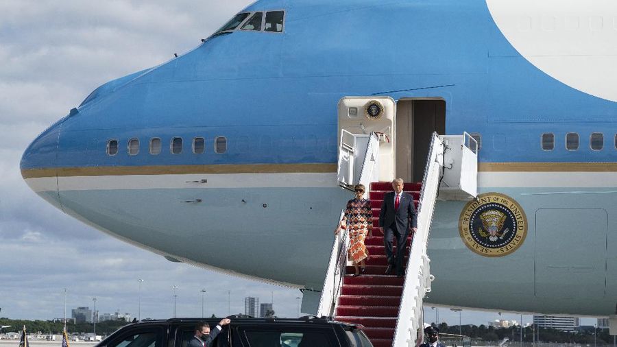 President Donald Trump and first lady Melania Trump arrive at Palm Beach International Airport in West Palm Beach, Fla., on Wednesday, Jan. 20, 2021. (Greg Lovett/The Palm Beach Post via AP)