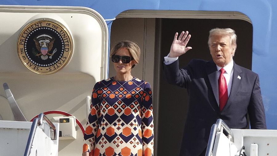 President Donald Trump waves to a handful of supporters as he arrives with first lady Melania Trump at Palm Beach International Airport in West Palm Beach, Fla., Wednesday, Jan. 20, 2021. (Joe Cavaretta/South Florida Sun-Sentinel via AP)