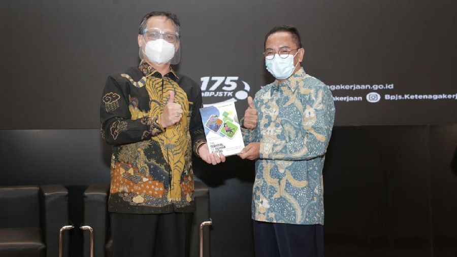 Naufal Mahfudz menyerahkan secara simbolis buku The Survival of Human Capital kepada Sumarjono, Direktur Perencanaan Strategis dan TI BP Jamsostek