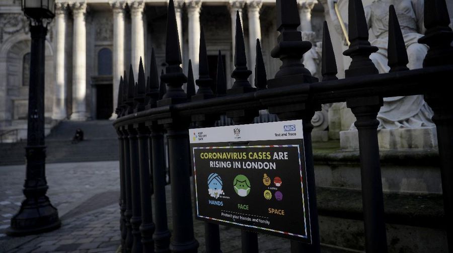 A coronavirus warning sign is displayed outside St. Paul's Cathedral, in the City of London financial district of London, Friday, Jan. 22, 2021, during England's third national lockdown since the coronavirus outbreak began. The U.K. is under an indefinite national lockdown to curb the spread of the new variant, with nonessential shops, gyms and hairdressers closed, most people working from home and schools largely offering remote learning. (AP Photo/Matt Dunham)