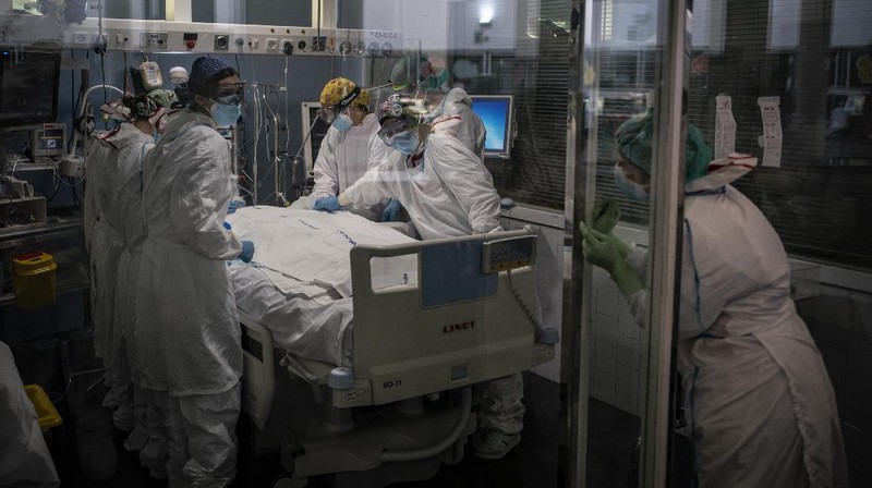 A COVID-19 patient receives treatment in the ICU of the Hospital del Mar, in Barcelona, Spain, Tuesday, Jan. 19, 2021. The unrelenting increase in COVID-19 infections in Spain following the holiday season is again straining hospitals, threatening the mental health of doctors and nurses who have been at the forefront of the pandemic for nearly a year. (AP Photo/Felipe Dana)