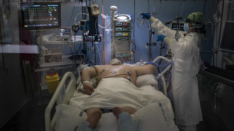 A COVID-19 patient receives treatment in the ICU of the Hospital del Mar, in Barcelona, Spain, Tuesday, Jan. 19, 2021. The unrelenting increase in COVID-19 infections in Spain following the holiday season is again straining hospitals, threatening the mental health of doctors and nurses who have been at the forefront of the pandemic for nearly a year. (AP Photo/Felipe Dana)
