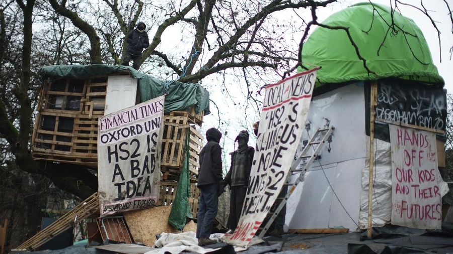Para pengunjuk rasa duduk di atas pepohonan di perkemahan di Euston Square Gardens di pusat kota London, Inggris, Rabu (27/1/2021). (AP/Aaron Chown)