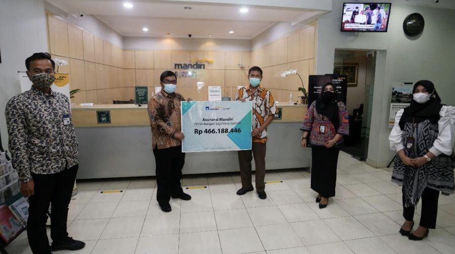 (Ki-Ka) Perwakilan AXA Mandiri mendampingi Area Manager Surabaya Kota Mandiri Syariah Edi Dwi Efendi, menyerahkan secara simbolis klaim biaya perawatan COVID-19 senilai lebih dari Rp 460 juta kepada penyintas COVID-19 Syamsul Hariadi di Surabaya, 28 Januari 2021. Syamsul merupakan pemegang polis Asuransi Mandiri Perlindungan Sejahtera Syariah. (Dok: Mandiri)