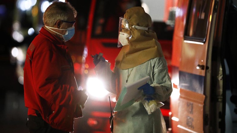 Petugas medis berdiri di samping ambulans saat mereka menunggu di rumah sakit Santa Maria, Lisbon, Portugal. (AP/Armando Franca)