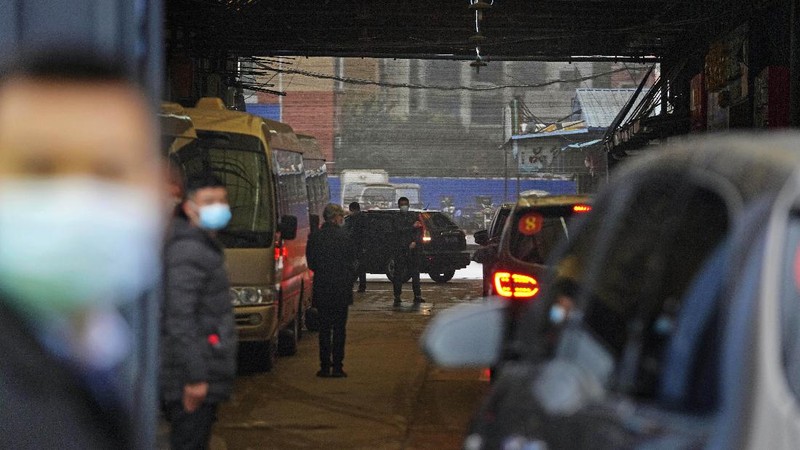 The World Health Organization team is briefed outside of the Huanan Seafood Market on the third day of their field visit in Wuhan, China, Sunday, Jan. 31, 2021. Scientists initially suspected the coronavirus came from wild animals sold in the market. The market has since been largely ruled out but for the visiting WHO team of international researchers it could still provide hints to how the virus spread so widely. (AP Photo/Ng Han Guan)