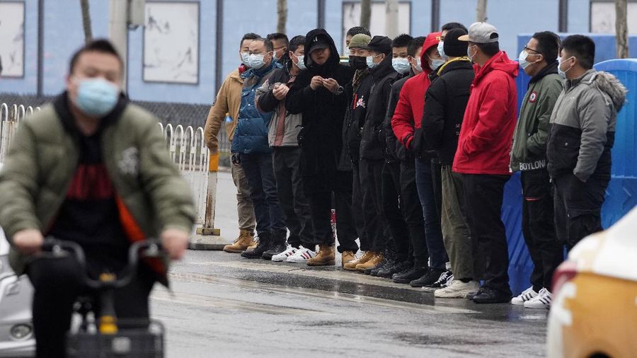 The World Health Organization team is briefed outside of the Huanan Seafood Market on the third day of their field visit in Wuhan, China, Sunday, Jan. 31, 2021. Scientists initially suspected the coronavirus came from wild animals sold in the market. The market has since been largely ruled out but for the visiting WHO team of international researchers it could still provide hints to how the virus spread so widely. (AP Photo/Ng Han Guan)