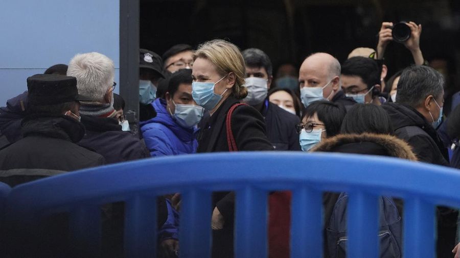 The World Health Organization team is briefed outside of the Huanan Seafood Market on the third day of their field visit in Wuhan, China, Sunday, Jan. 31, 2021. Scientists initially suspected the coronavirus came from wild animals sold in the market. The market has since been largely ruled out but for the visiting WHO team of international researchers it could still provide hints to how the virus spread so widely. (AP Photo/Ng Han Guan)