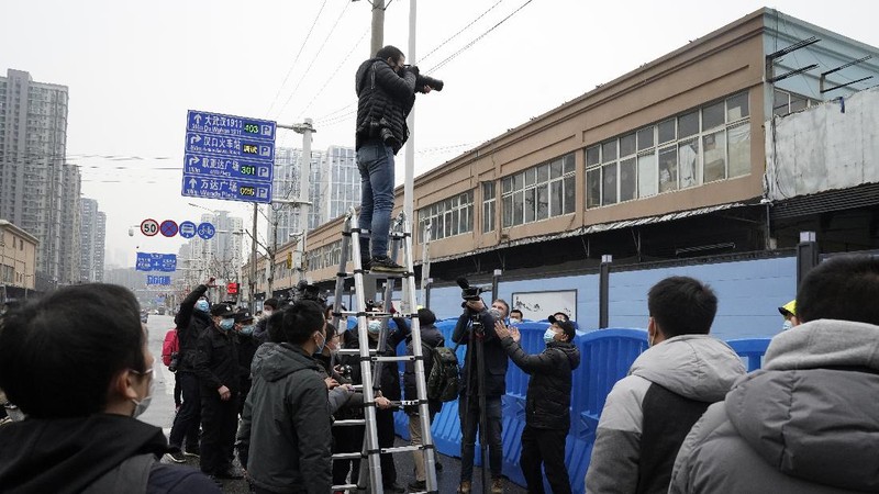 The World Health Organization team is briefed outside of the Huanan Seafood Market on the third day of their field visit in Wuhan, China, Sunday, Jan. 31, 2021. Scientists initially suspected the coronavirus came from wild animals sold in the market. The market has since been largely ruled out but for the visiting WHO team of international researchers it could still provide hints to how the virus spread so widely. (AP Photo/Ng Han Guan)